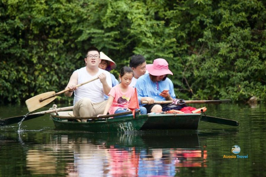 A family experiences sampan boat in Trang An, Ninh Binh, Vietnam